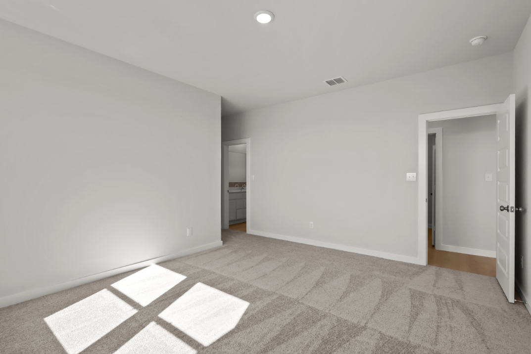 A room with white walls and a rug.