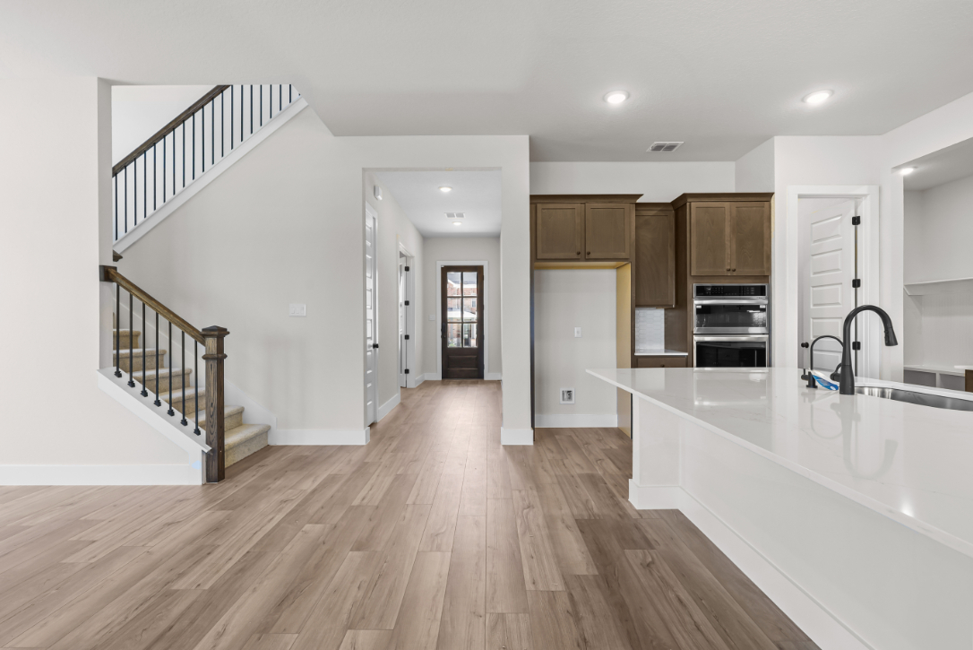 A large kitchen with a wood floor.