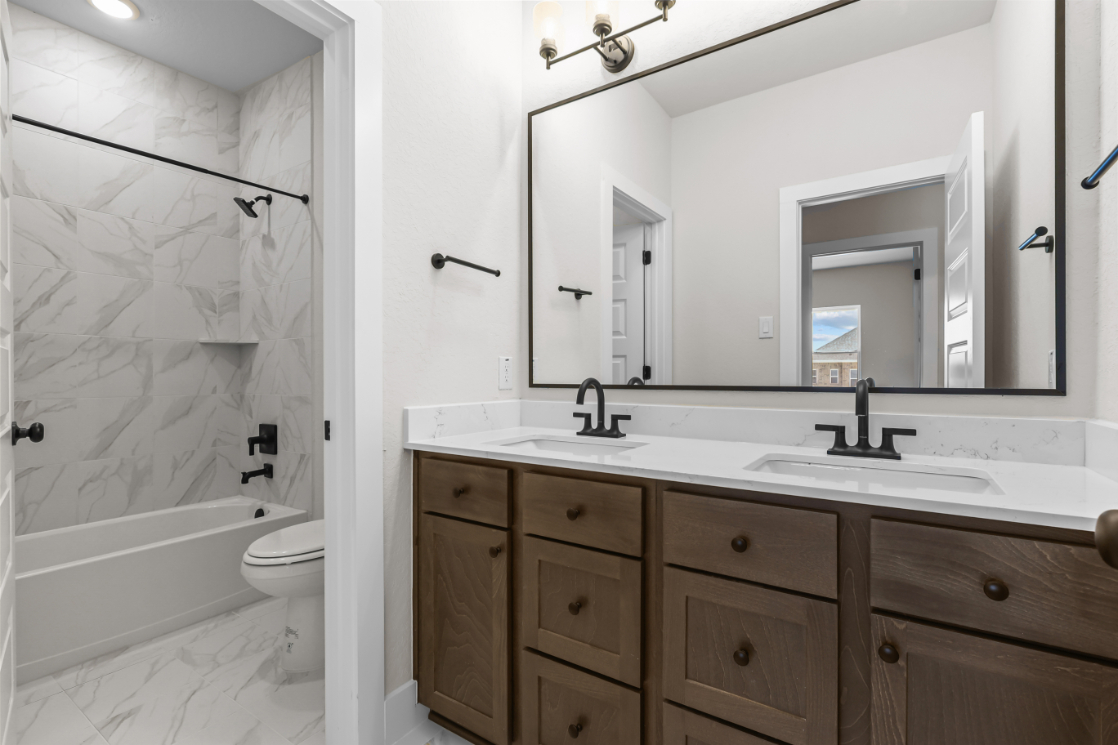 A bathroom with a tub sink and toilet.
