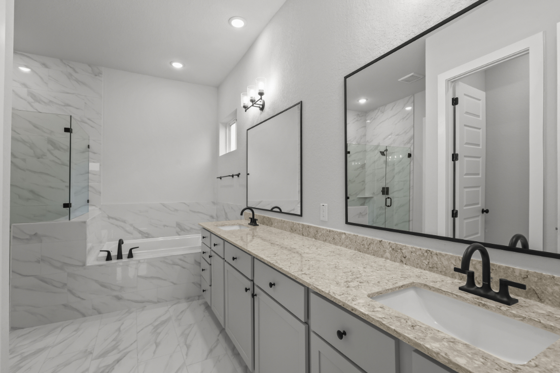 A bathroom with a tub sink and mirror.