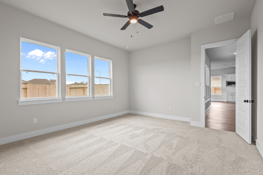 A room with a ceiling fan and a window.