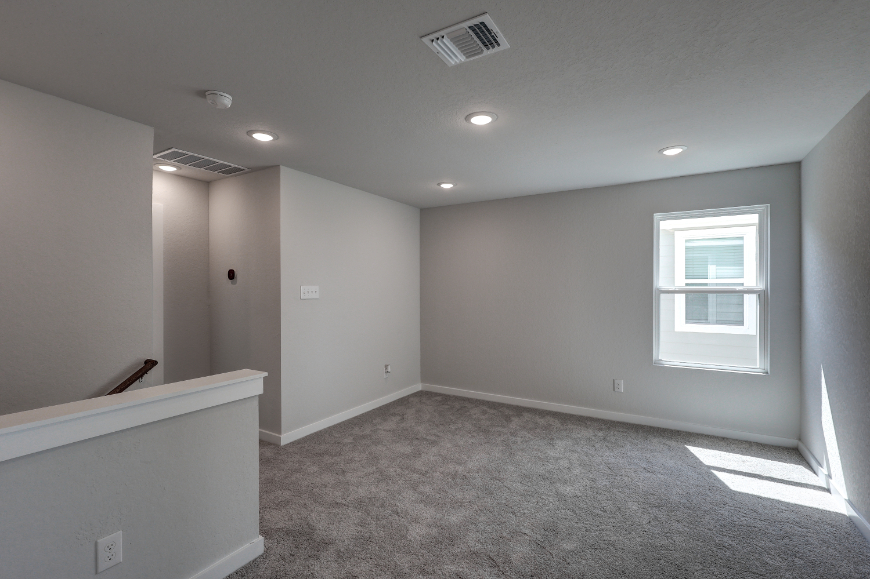 A room with a white wall and a window.