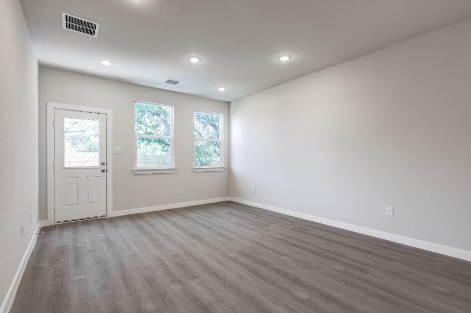A room with a wood floor and a white door.