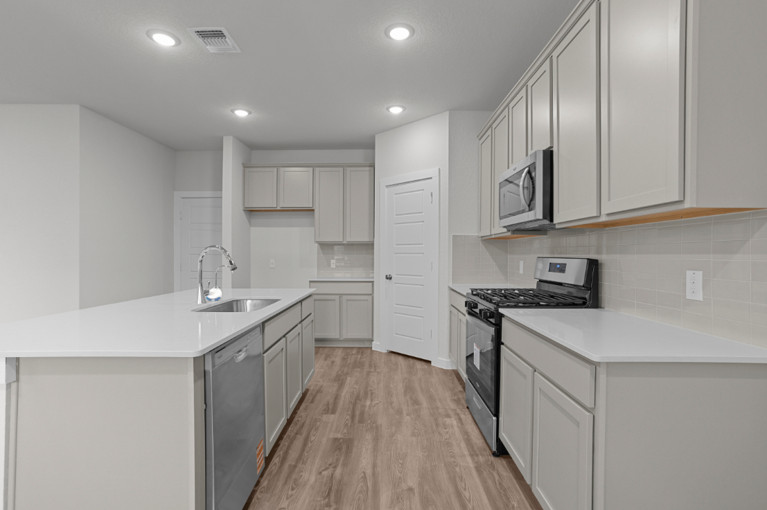 A kitchen with white cabinets.