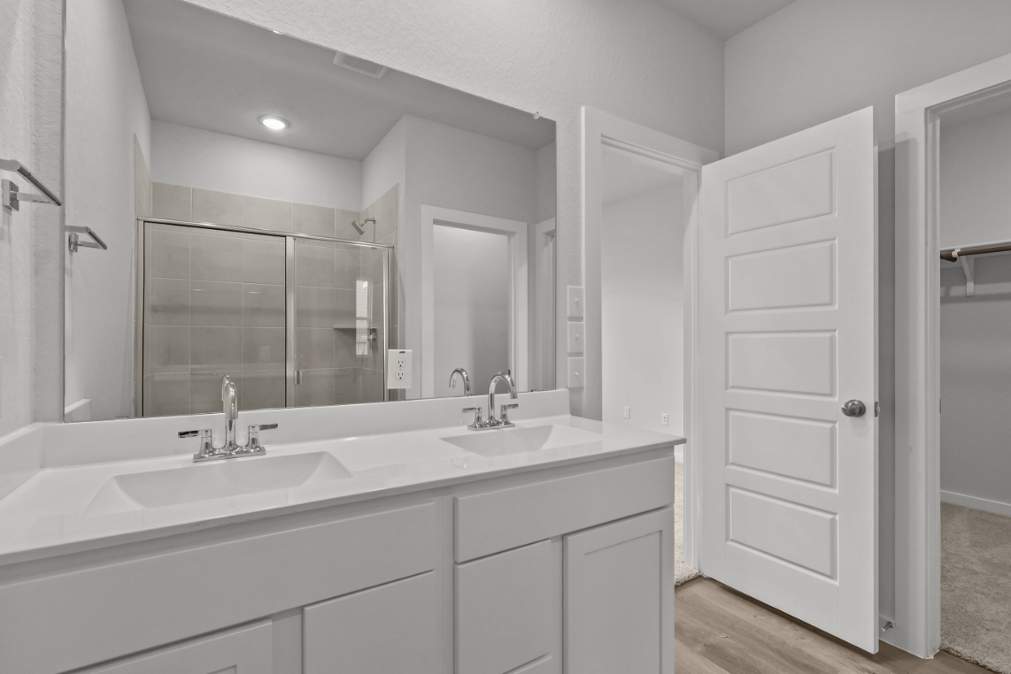 A bathroom with white cabinets.