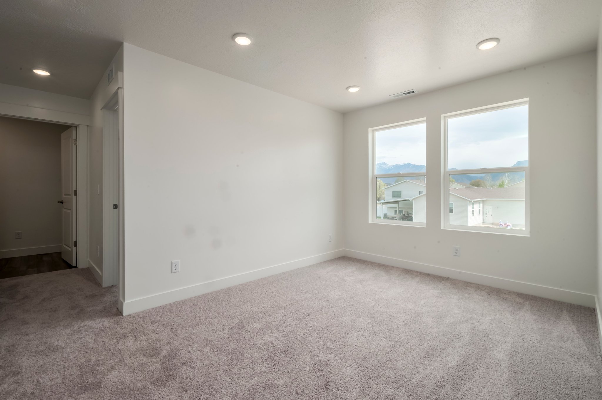 A room with a window and a carpet.