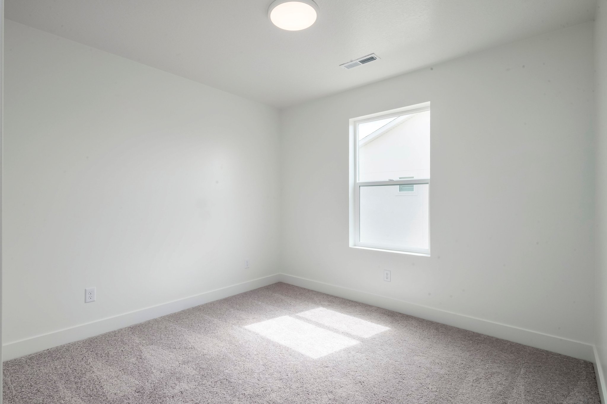 A room with a window and a carpet.