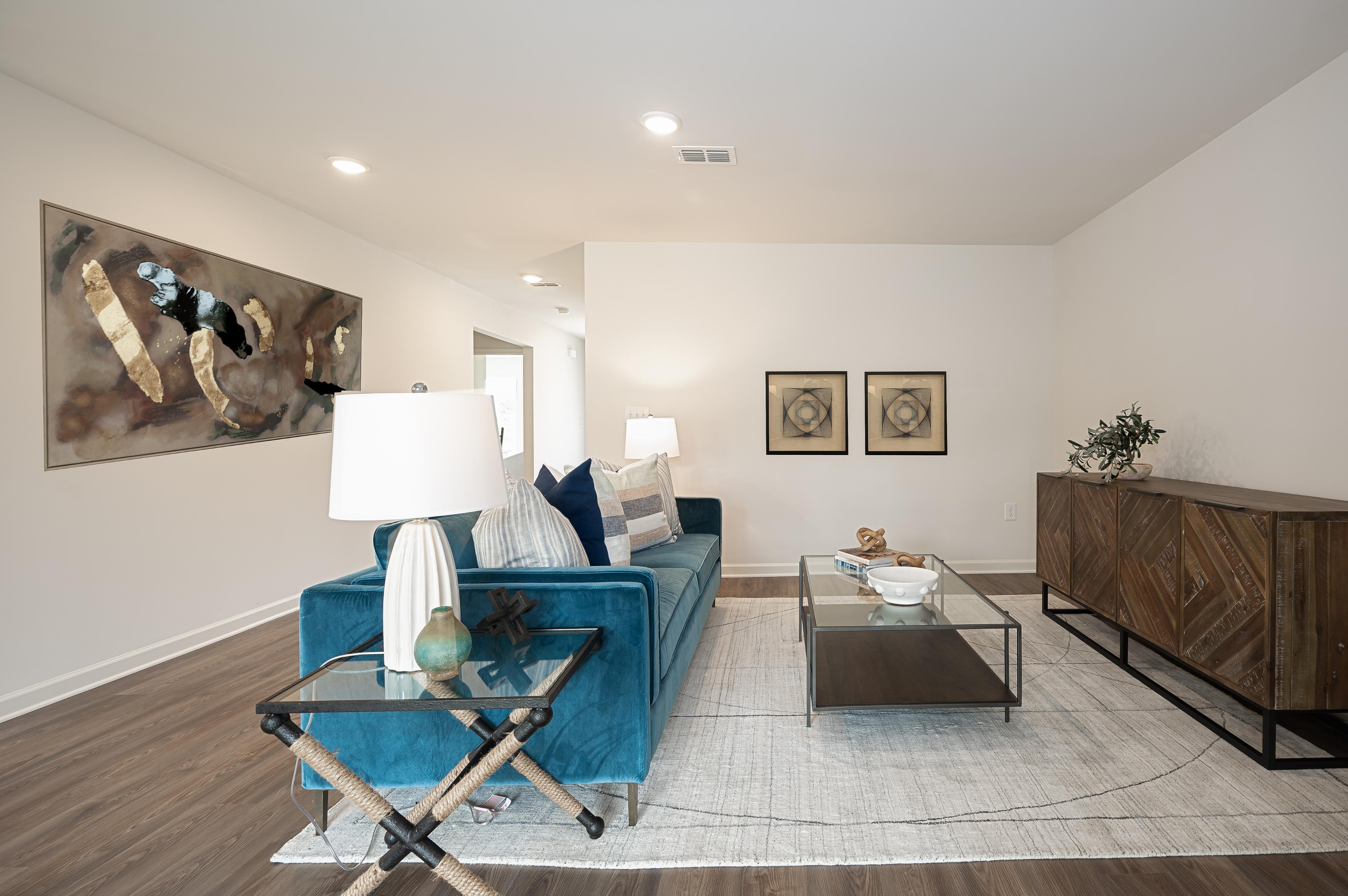 A living room with a bed and a desk.