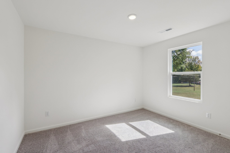 A room with a window and a rug in it.