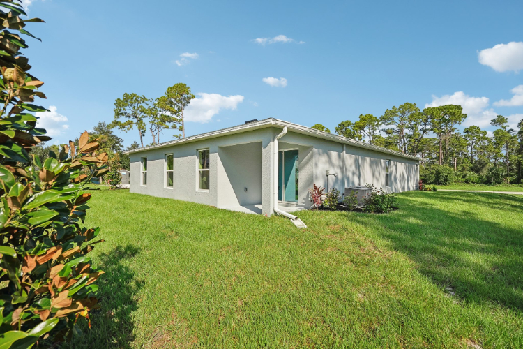 A white house with a grass yard.