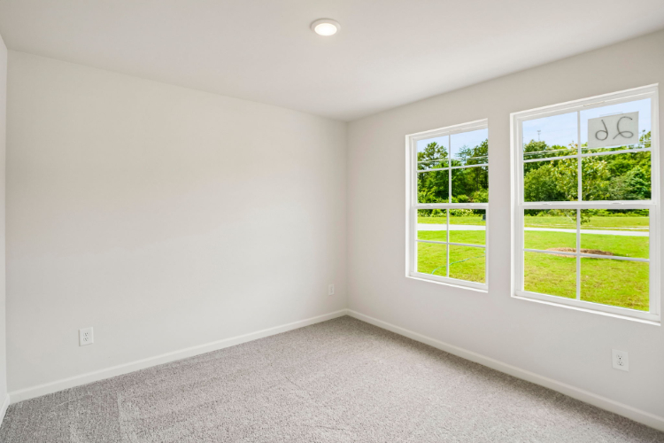 A room with windows and a white wall with a white wall and a green field.