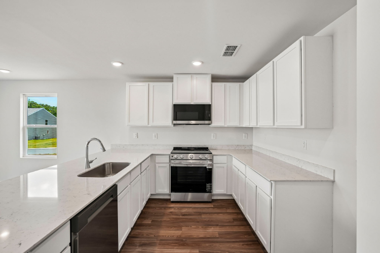 A kitchen with white cabinets.