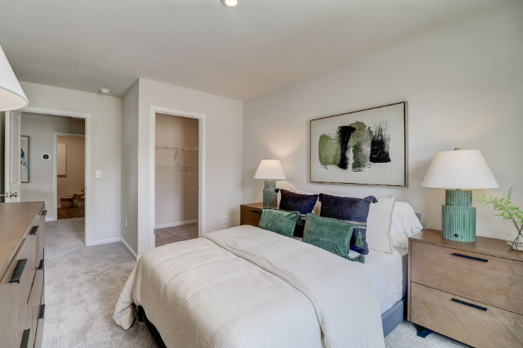 A bedroom with a bed and lamps.