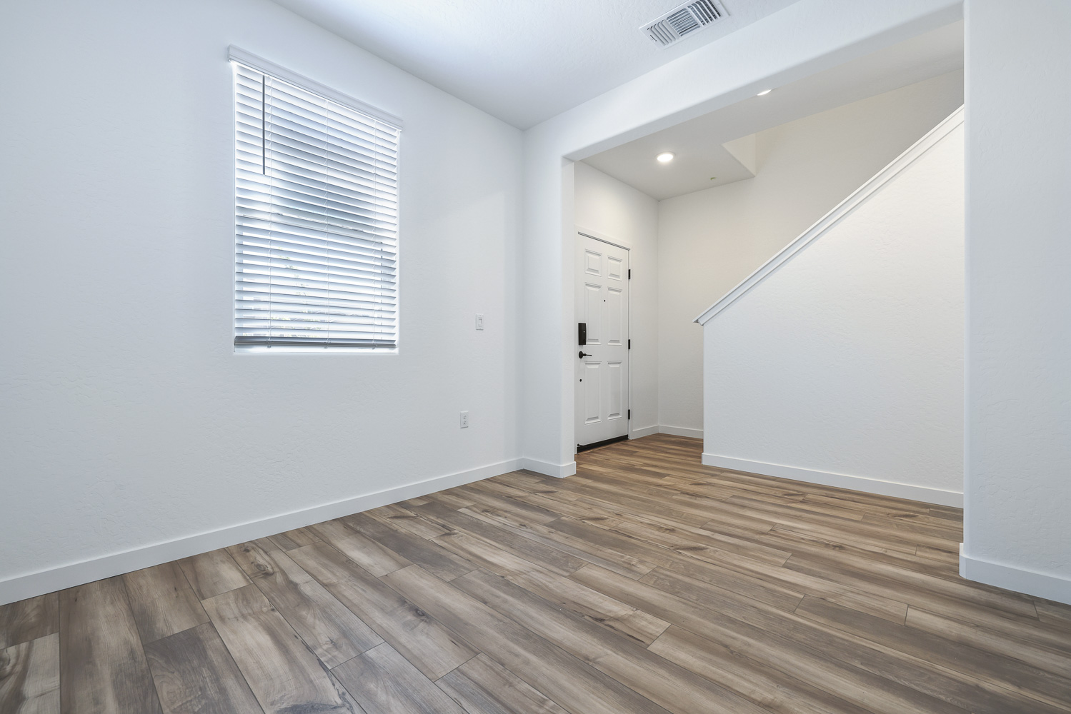 A room with white walls and wood floors.