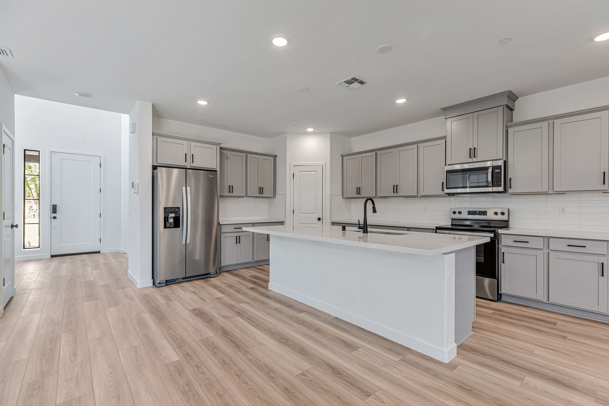 A kitchen with white cabinets.