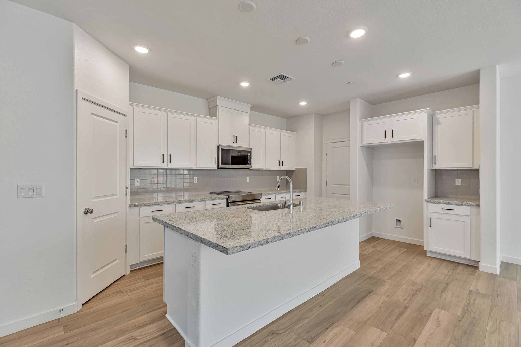 A kitchen with white cabinets.