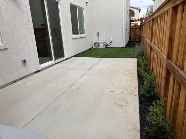 A backyard with a fence and a house.